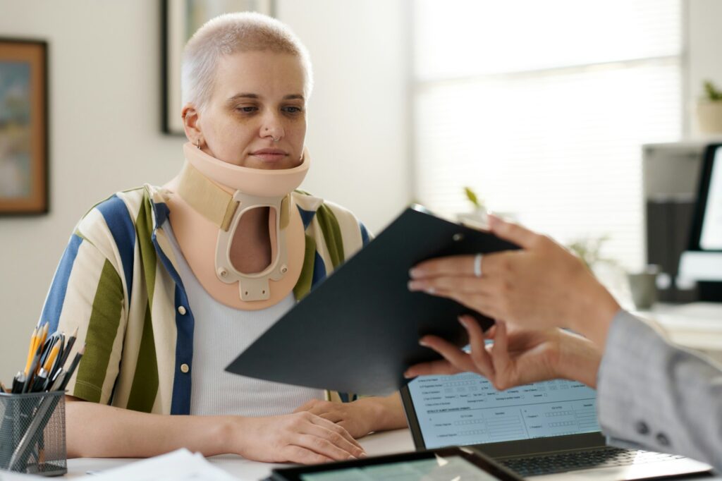Woman with injury signing contract with insurance agent